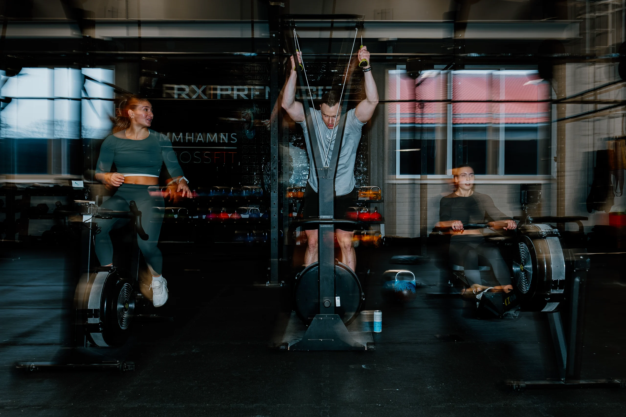 Athlete driving a loaded sled across a dark industrial gym floor
