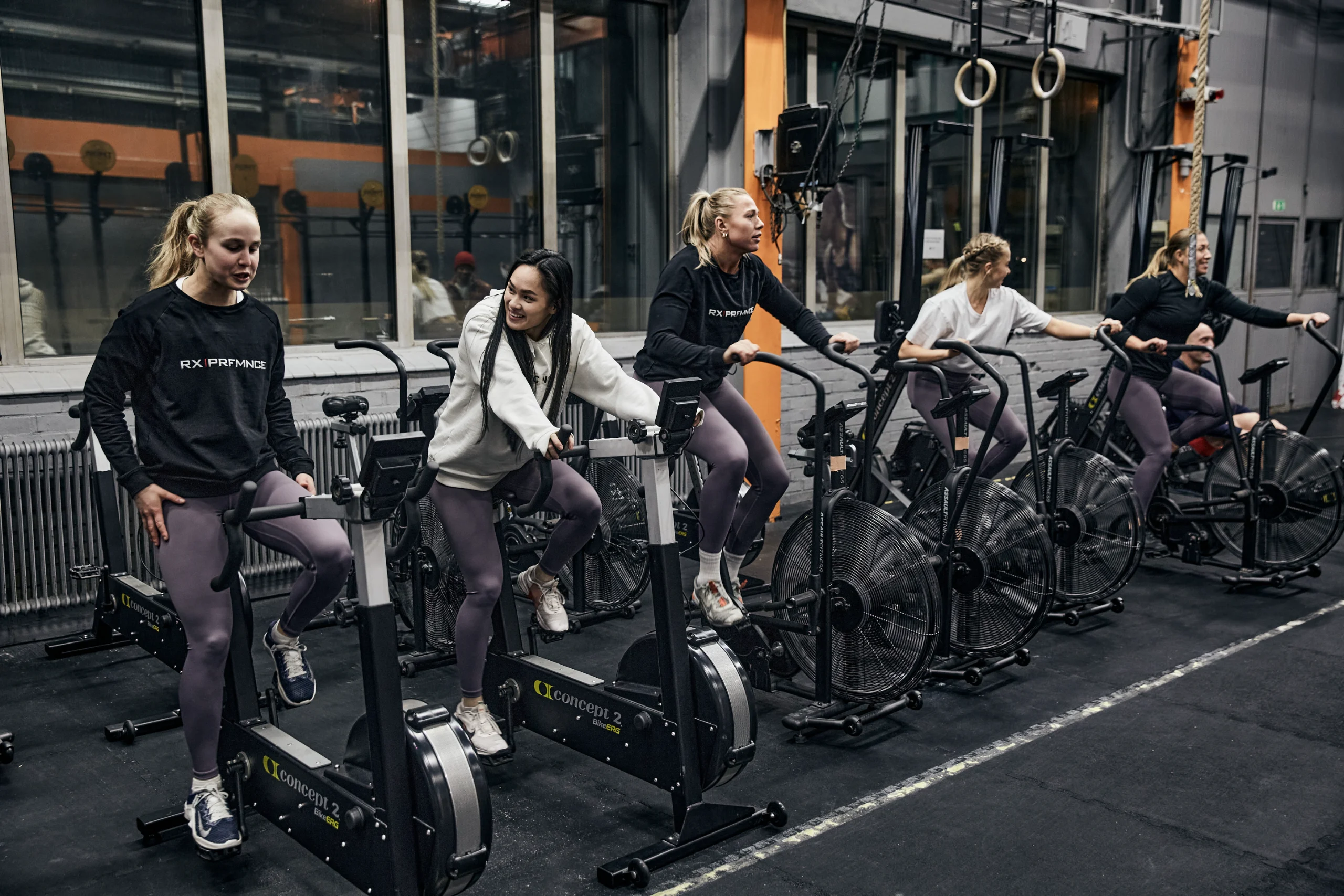 Interior of an industrial functional fitness gym with rowers and sleds